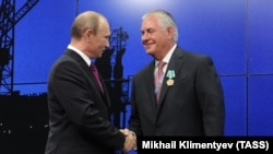 Russian President Vladimir Putin (left) shakes hands with then-Exxon Mobil Chief Executive Rex Tillerson during a meeting in June 2013.