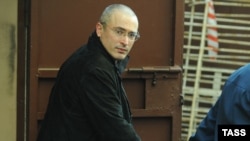 Handcuffed former Yukos head Mikhail Khodorkovsky is led away from Moscow's Khamovniki District Court