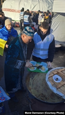 Darmenov hands out plov at the opening of a Yurt of Invincibility in Novovolynsk in January.