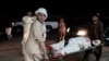 A wounded man is carried on a stretcher outside a hospital following a car bomb in Lashkar Gah on March 23.