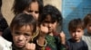 Children show their fingers marked with ink after getting polio vaccine in a campaign in the southern Afghan city of Kandahar in June 2022.