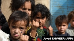 Children show their fingers marked with ink after getting polio vaccine in a campaign in the southern Afghan city of Kandahar in June 2022.