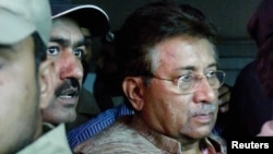 Former President and head of the All Pakistan Muslim League (APML) political party Pervez Musharraf (right) is escorted by security officials as he leaves an antiterrorism court in Islamabad in April.