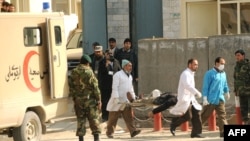 Medical personnel carry an injured person from the Justice Ministry in Kabul during the February 11 attacks.