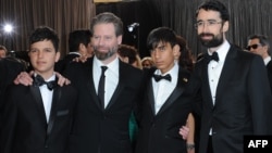 Actors Fawad Mohammadi (second from right) and Jawanmard Paiz (left) arrive with director Sam French (second from left) and producer Ariel Nasr on the red carpet for the 85th annual Academy Awards.