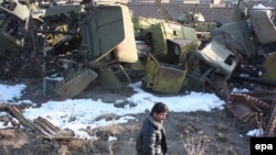 Afghan man surveys a warehouse containing scraps of Soviet-era military vehicles and tanks in Kabul