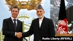 NATO Secretary-General Anders Fogh Rasmussen (left) Afghan President Hamid Karzai after the security handover to Afghan forces in Kabul on June 18.