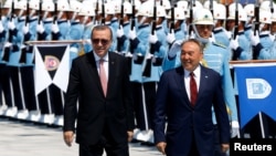 Turkish President Recep Tayyip Erdogan (left) and Kazakh President Nursultan Nazarbaev review an honor guard in Ankara on August 5.