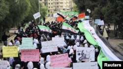 Antigovernment demonstrators march in the town of Homs, one of the most restive Syrian cities, in late November.