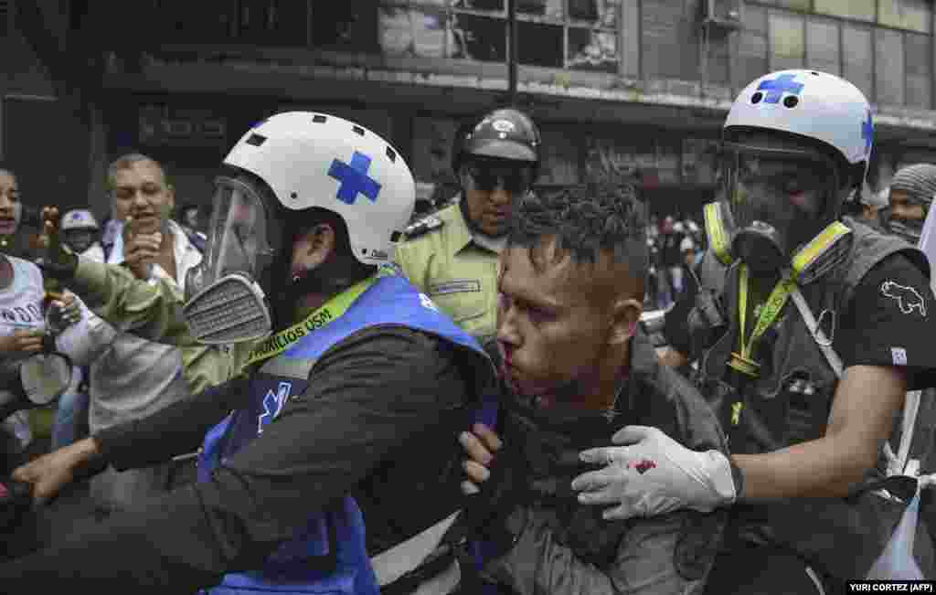 Paramedics rescue a wounded member of the national guard during clashes with opposition demonstrators. The January 23 protests took place on the anniversary of&nbsp;the 1958 uprising that overthrew Venezuela&#39;s military dictatorship.