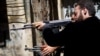 Members of the Free Syrian Army shoot at a nearby government army position in the Al-Jadeida neighbourhood of Aleppo.