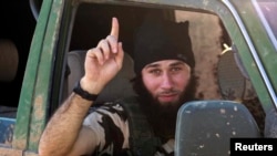 An Islamic State fighter gestures from a vehicle near the Syrian town of Kobani after IS fighters took control of the area in October 2014. When it comes to working face-to-face to deradicalize young people, there appears to be little difference between the methods used with neo-Nazis and with foreign fighters from IS or Al-Qaeda. (file photo)