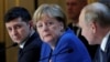 Ukraine's President Volodymyr Zelenskiy and German Chancellor Angela Merkel listen to Russia's President Vladimir Putin as they attend a joint news conference in Paris on December 10.