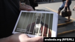 A supporter holds a flyer showing jailed rights activist Ales Byalyatski in Minsk.