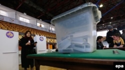 A woman holds a ballot paper at a voting center in Pristina, Kosovo.