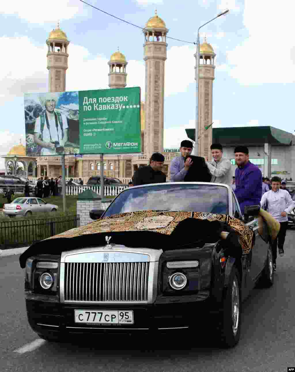 Kadyrov (right) rides in a Rolls-Royce Cabriolet in Grozny in 2011.