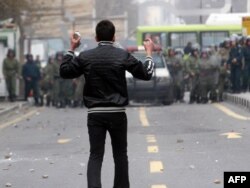 An Iranian opposition protester faces security forces during clashes in Tehran in December 2009, following the reelection of Mahmud Ahmadinejad as president.