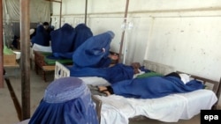 Schoolgirls receive first aid after inhaling a mysterious poisonous gas in Takhar in late May.