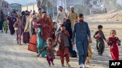 Afghan refugees in Pakistan walk towards the Pakistan-Afghanistan border in Torkham on November 3. 