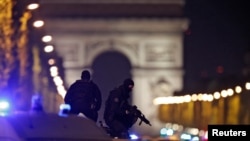 Masked police stand on top of their vehicle on the Champs-Elysees Avenue after the shooting late on April 20.