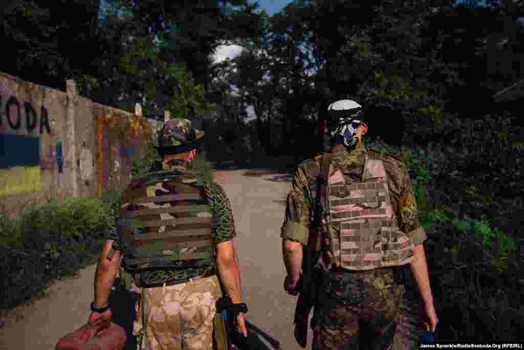 Dan and Chemist, from the 93rd Brigade, walk toward their front line positions, where they will spend the next few hours observing enemy positions in Donetsk.