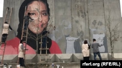 The mural in Kabul of slain human rights activist Hamida Barmaki as it was being painted. 