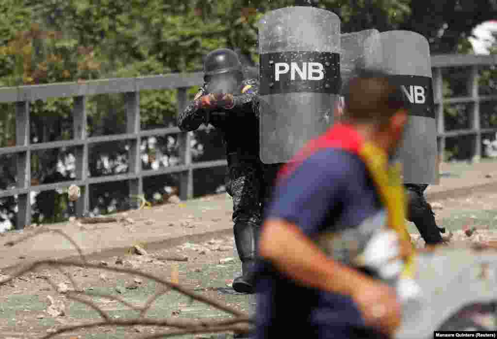 A police officer fires rubber bullets during a protest against the government of Venezuelan President Nicolas Maduro in Caracas on January 23.&nbsp;Maduro was sworn in early in January following his reelection in a poll considered fraudulent by much of the international community.