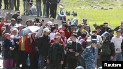 Riot police form a line near people who gathered at the settlement of Nizhnaya Alaarcha outside Bishkek on April 20.