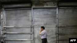 A man walks past a shuttered shop in Tehran's Bazaar.