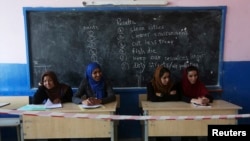 Afghan observers sit at a polling station in Kabul in the second round of the presidential election on June 14.