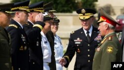 Russian General of the Army Nikolai Makarov (right) is introduced by U.S. Chief of Staff General Patrick Dempsey (center) during a full honor cordon at the Pentagon in Washington on July 12.