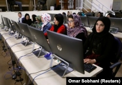 Afghan election workers wait for vote-count papers at the database center of the Afghanistan Independent Election Commission in Kabul on October 24.