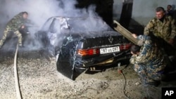 Firefighters extinguish a burning car after shelling by Azerbaijan's military in Stepanakert, in the breakaway region of Nagorno-Karabakh.