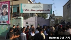 People gather at the site of the deadly suicide bombing that targeted a training class in the Shi'ite neighborhood of Dasht-e Barchi, in western Kabul, on August 15, 2018.