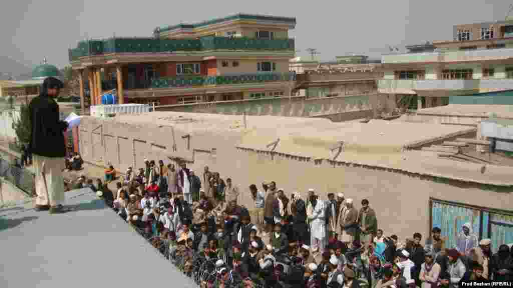 An employee at a registration office calls out the names of those who are to make their way through the gate entrance.