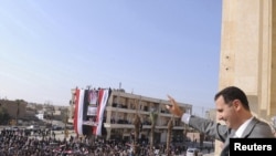 Syrian President Bashar al-Assad greets the crowd during a visit to Raqqa on November 6.