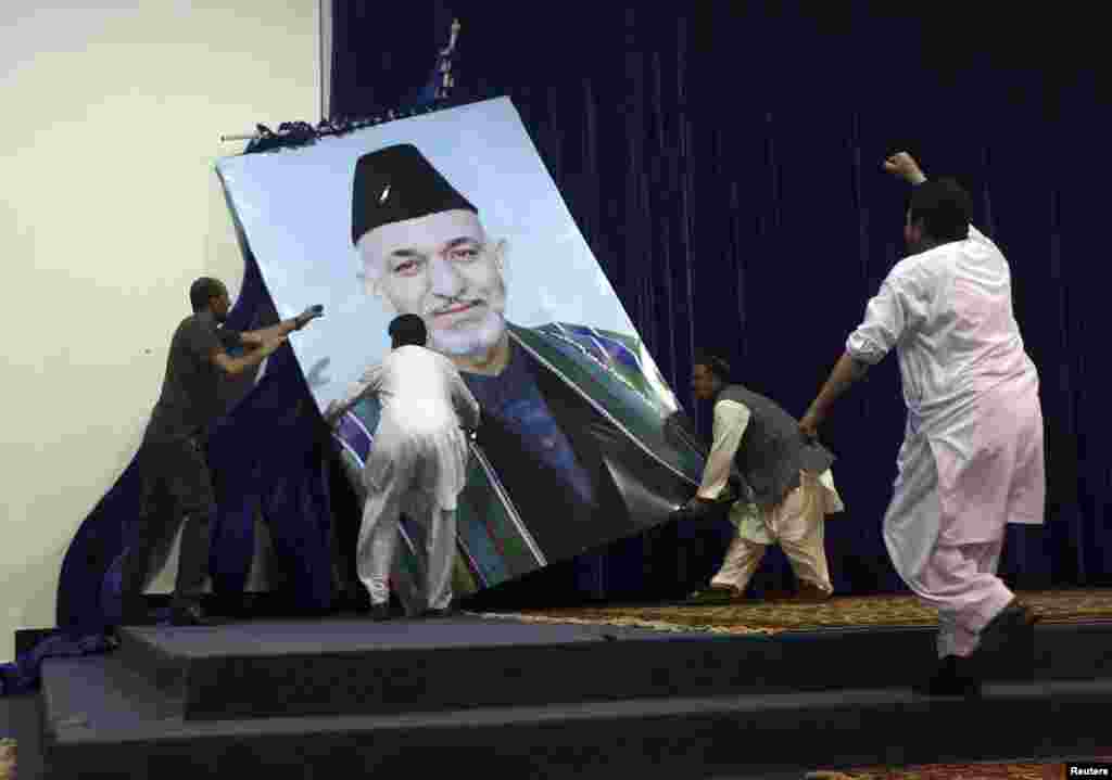 Angry supporters&nbsp;of&nbsp;Afghan presidential candidate Abdullah Abdullah tear&nbsp;down a large portrait of&nbsp;Karzai before a rally&nbsp;in Kabul on July 8, 2014. Abdullah claimed vote fraud in the June runoff election against Ashraf Ghani. Abdullah&#39;s supporters accused Karzai of rigging the runoff in Ghani&#39;s favor. 