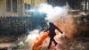 <div>
<div>A masked police officer kicks a smoke bomb on November 29 during the second night of protests after the Georgian government announced the suspension of EU accession talks.</div>
</div>
<div>&nbsp;</div>
