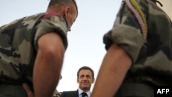 French President Nicolas Sarkozy (center) speaks with troops in Afghanistan on August 20 after 10 French soldiers were killed.