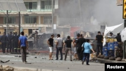 Iraqis gather at the site of a bomb attack in central Baghdad on July 31.