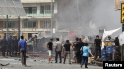 Residents gather at the site of a bomb attack in central Baghdad on July 31 that killed 20 people.