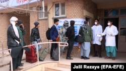 Afghan health officials screen people entering Afghanistan from Iran at the border in Herat Province last month.