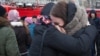 Two girls comfort each other as they cry near the site of a shopping-mall fire in the Siberian town of Kemerovo that left scores of people dead, many of them children. 