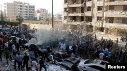 Soldiers, police officers, and medical personnel gather at the site of explosions near the Iranian Embassy (left) in Beirut on November 19.