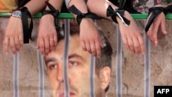 Russian demonstrators with a poster of Georgian President Mikheil Saakashvili behind bars in August 2008 -- a wish Moscow failed to see realized.