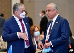 Tajik Foreign Minister Sirojiddin Muhriddin (left) speaks with the special U.S. envoy to Afghanistan, Zalmay Khalilzad, at the Central and South Asia 2021 conference in Tashkent on July 16.