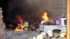 A car is engulfed by flames during clashes in Ramadi on May 16.