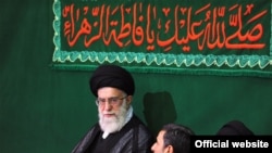 Supreme Leader Ali Khamenei (center) and President Mahmud Ahmadinejad (to his immediate left) during a religious ceremony on May 7