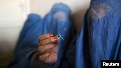 A woman holds up opium as she attends a counseling session at the Nejat drug rehabilitation center in Kabul.