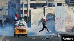 A demonstrator throws away a tear gas canister during an anti-government protest in Baghdad on November 1.